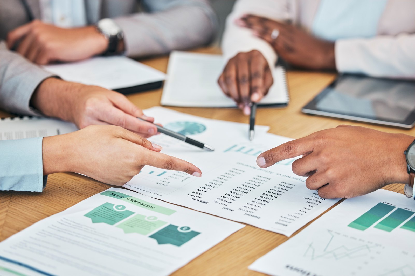 Mains de collaborateurs comparant des indicateurs