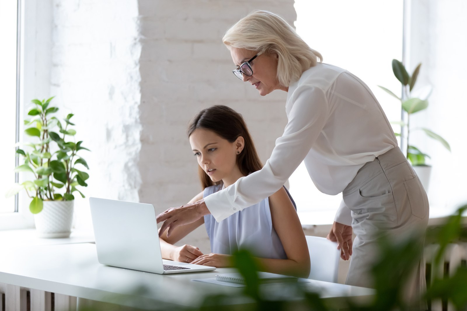 Responsable accompagnant une collaboratrice devant un ordinateur
