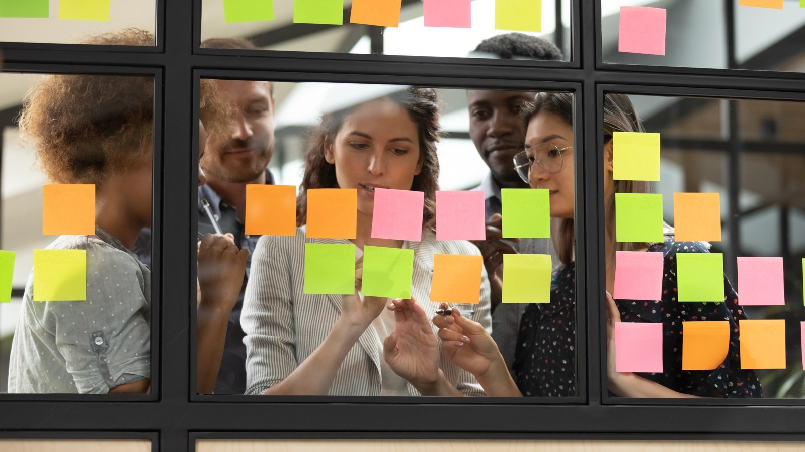 Équipe regroupant des idées sur des notes adhésives