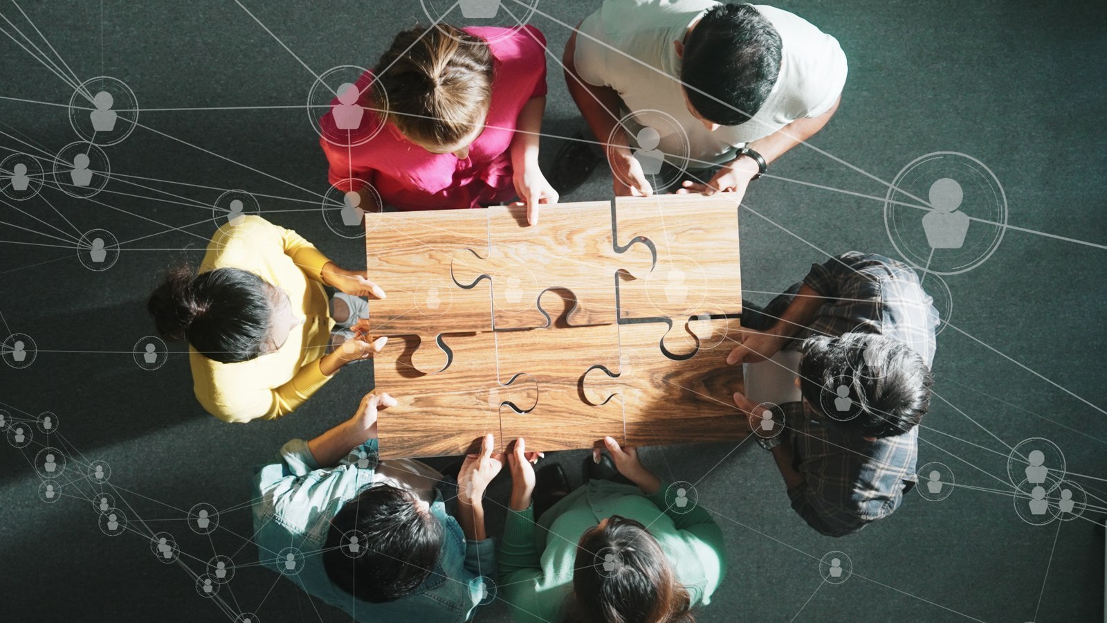 Équipe assemblant un puzzle autour d’une table