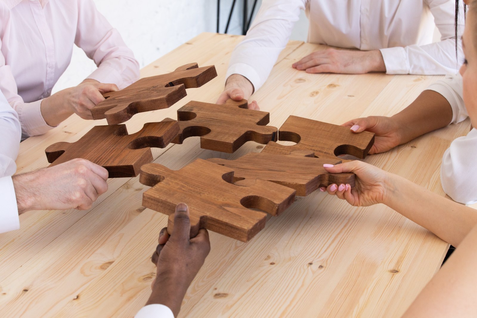 Collaborateurs rapprochant les pièces d’un puzzle en bois